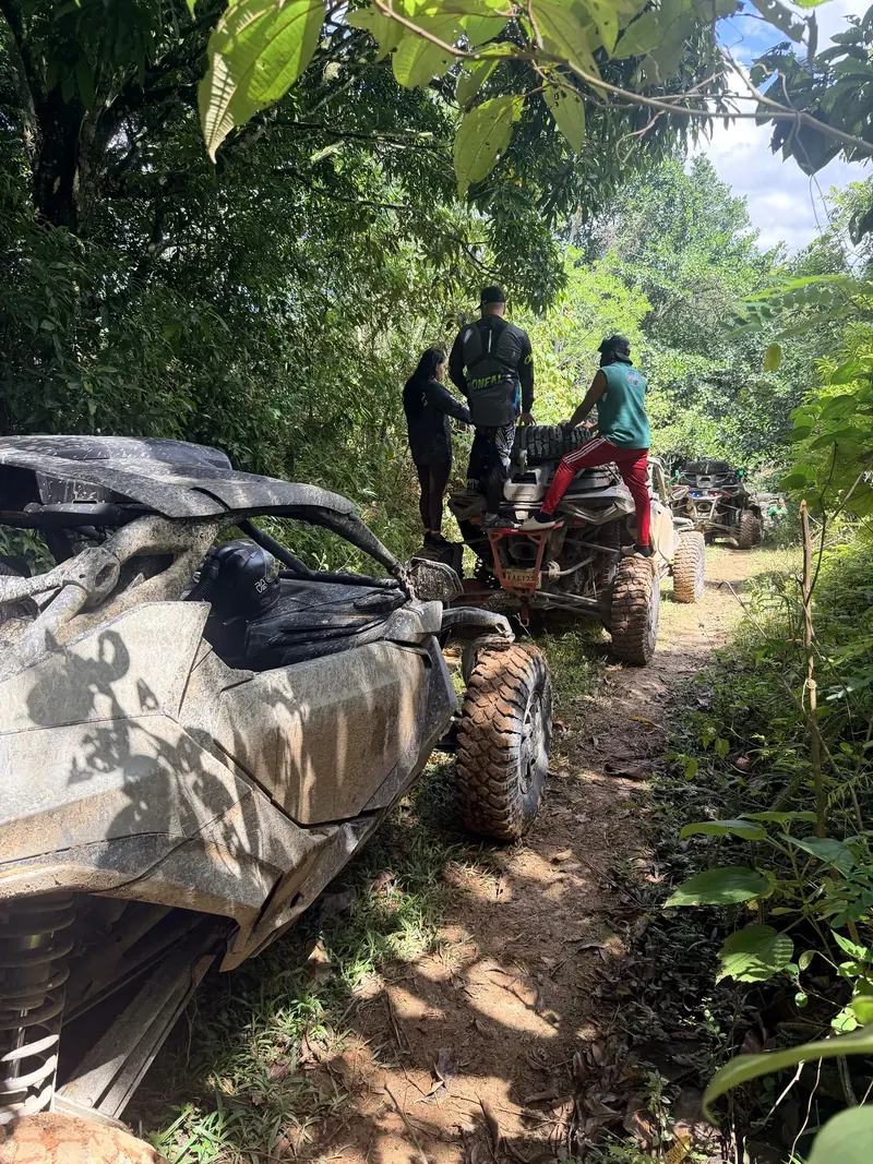 Miembros del equipo manipulando una rueda de repuesto en un Can-Am, en una pista del bosque