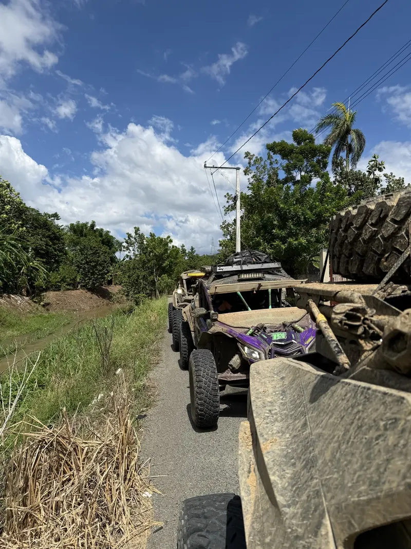 Caravana de Can-Am por una carretera rural dominicana, bajo un cielo azul