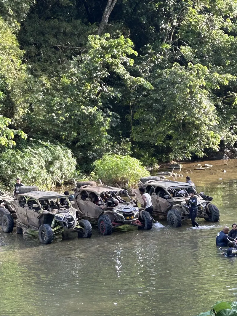 Varios Can-Am detenidos en un río, con personas alrededor en el agua